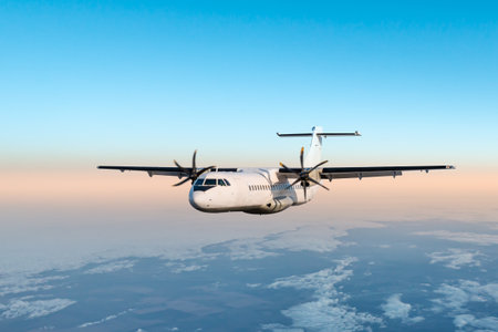 White passenger turboprop plane flying in the morning air above the clouds