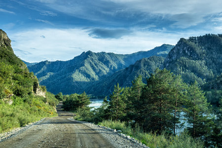A picturesque dirt road along a mountain riverの写真素材
