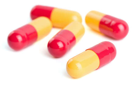 red and yellow capsule pills isolatedの写真素材