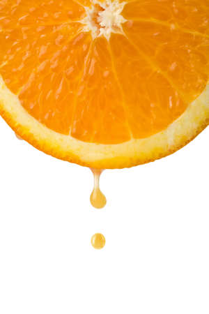 drop of juice falling from orange half isolatedの写真素材
