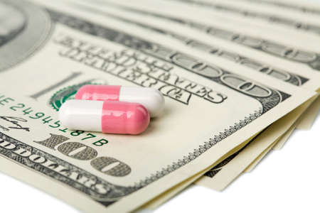 macro of capsule pills over dollar banknotes isolatedの写真素材