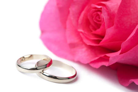 Gold wedding rings and pink rose isolatedの写真素材