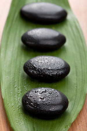 black spa stones over leaf 