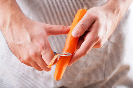 man hands peeling carrotの写真素材