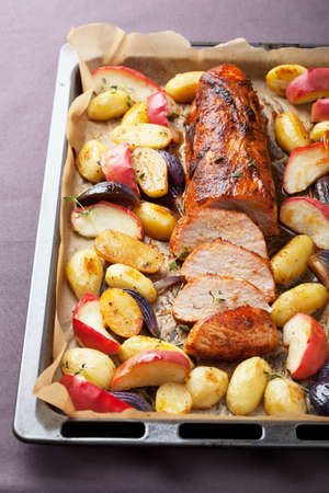 pork baked with vegetables on a trayの写真素材