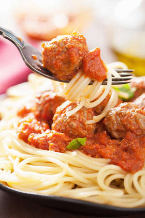 spaghetti with meatballs in tomato sauce on forkの写真素材