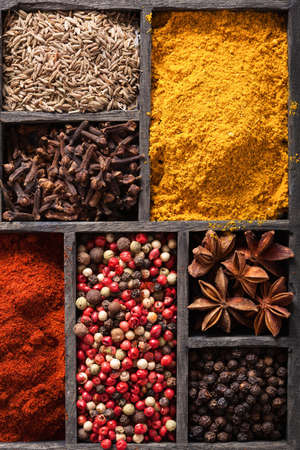 spices in box: pink and black pepper, ground paprika, curry, anise; clove; cumin の写真素材