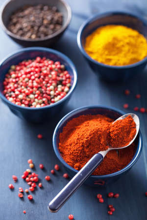 spices in bowls: curry, pink black pepper, paprika powder の写真素材
