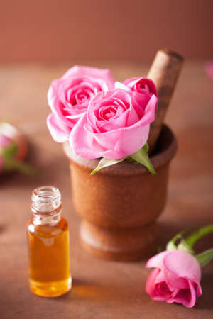 mortar with rose flowers and essential oil for aromatherapy and spa の写真素材