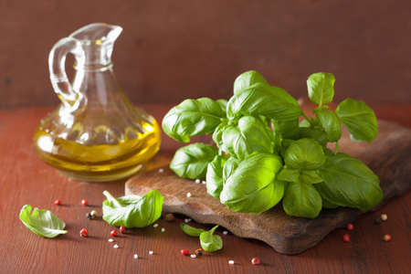 fresh basil leaves herb and olive oil on wooden bacgkroundの写真素材
