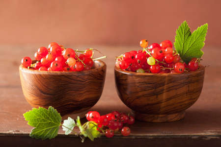 fresh redcurrant in cups over rustic wooden backgroundの写真素材
