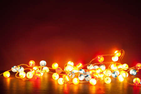 burning christmas lights decoration over red background