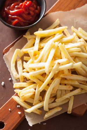 french fries with ketchup over rustic background