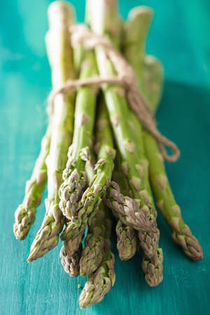 bunch of fresh asparagus on turquoise backgroundの写真素材