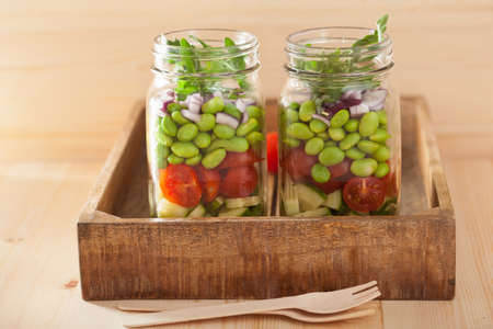 healthy vegetable salad in mason jar: tomato, cucumber, soybean, onionの写真素材