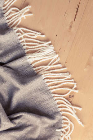 warm wool throw plaid on wooden backgroundの写真素材