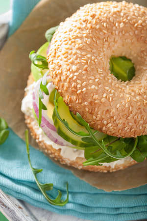 avocado sandwich on bagel with cream cheese onion cucumber arugulaの写真素材