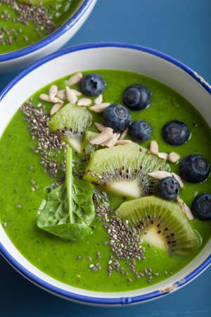 green smoothie bowl spinach kiwi blueberry banana with chia seedの写真素材