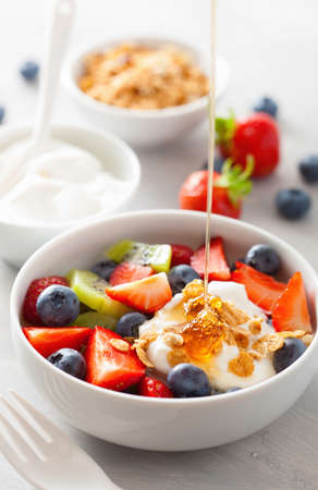 fruit berry salad with yogurt and granola for healthy breakfastの写真素材