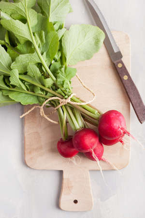 fresh raw radish with leaves over gray background