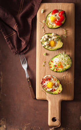 eggs baked in avocado with bacon, cheese, tomato and alfalfa sproutsの写真素材