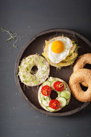 variety of sandwiches on bagels: egg, avocado, ham, tomato, soft cheese, alfalfa sproutsの写真素材