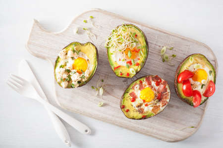 eggs baked in avocado with bacon, cheese, tomato and alfalfa sproutsの写真素材