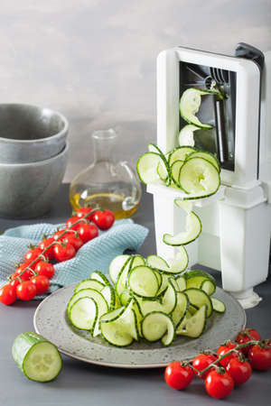 spiralizing cucumber vegetable with spiralizerの写真素材