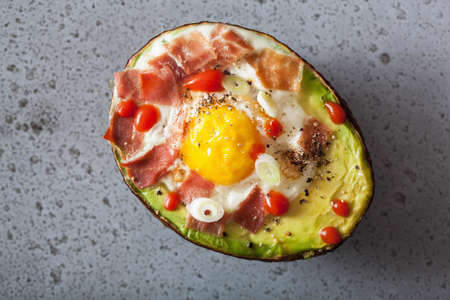 egg baked in avocado with bacon and spring onionの写真素材