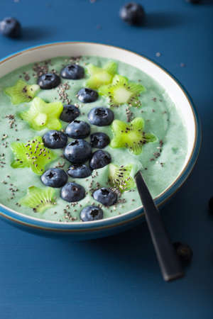 healthy spirulina smoothie bowl with blueberry, kiwi stars, chia seed