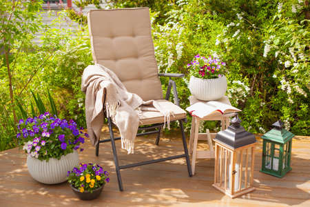 garden chair on terrace in sunlight, pansy flowersの写真素材