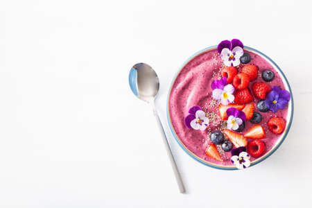 healthy summer berry smoothie bowl with flowers and chia seedの写真素材