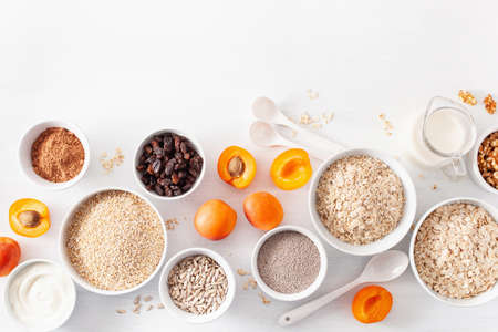variaty of raw cereals, fruits and nuts for breakfast. Oatmeal flakes and steel cut, barley, walnut, chia, apricot. Healthy ingredientsの写真素材