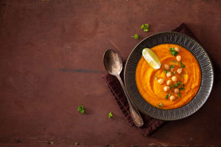 creamy carrot chickpea soup on dark rustic backgroundの写真素材