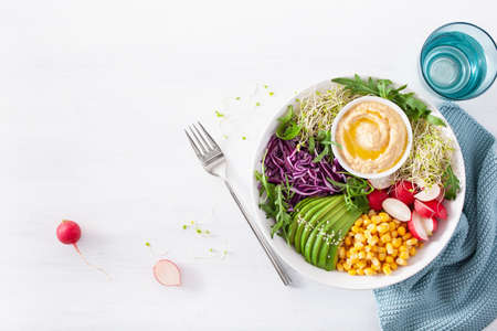 vegan avocado sweet corn lunch bowl with hummus, red cabbage, radish and sprouts