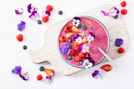 healthy summer berry smoothie bowl with flowers and chia seedの写真素材