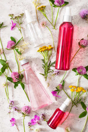 bottles skincare lotion serum medical flowers herbs. natural cosmetic. clover milfoil tansy rosebayの写真素材