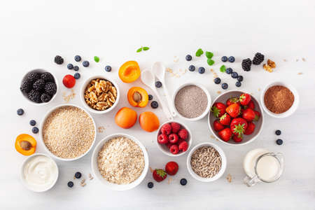 variaty of raw cereals, fruits and nuts for breakfast. Oatmeal flakes and steel cut, barley, walnut, chia, apricot, strawberry. Healthy ingredientsの写真素材