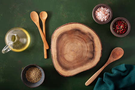 empty serving board salt pepper spoon on green backgroundの写真素材