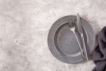 empty plate fork knife on concrete backgroundの写真素材