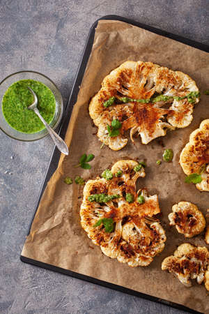 cauliflower steaks with herb and spice on baking tray. plant based meat substituteの写真素材
