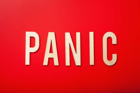 panic word text wooden letter on red backgroundの写真素材
