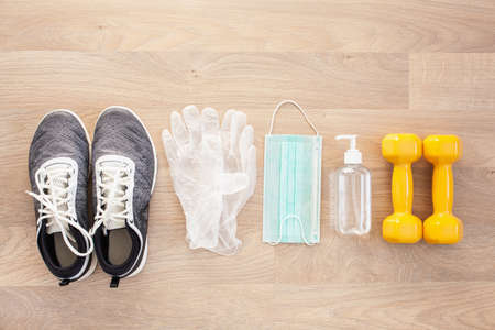 protective medical mask sanitizer gel gloves. home fitness training sneakers dumbbell and protective measures against virus, bacteriaの写真素材