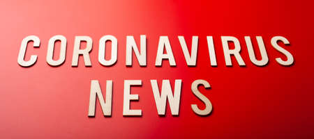 coronavirus news word text wooden letter on red background corona virus covid-19の写真素材