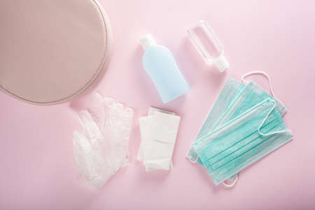 protective medical mask, sanitizer gel and gloves in pink bag. protective measures against virus, bacteriaの写真素材
