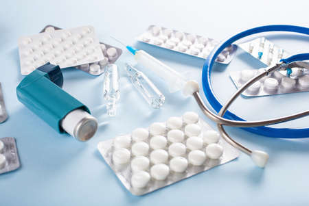 Pills, stethoscope, syringe and asthma inhaler  on blueの写真素材