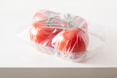 single use plastic packaging issue.tomatoes vegetables in plastic bagの写真素材