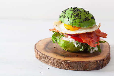 keto paleo diet avocado breakfast burger with bacon, egg, tomatoの写真素材