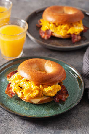 breakfast egg and bacon sandwich on bagel with cheeseの写真素材