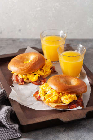 breakfast egg and bacon sandwich on bagel with cheeseの写真素材